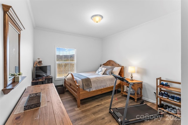 bedroom with dark wood-style floors, ornamental molding, and baseboards