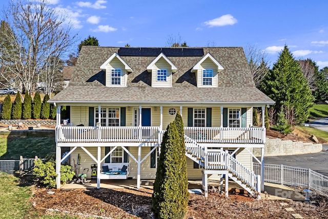 view of front of home featuring a porch, stairway, and a shingled roof