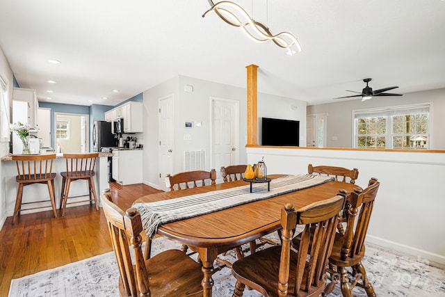 dining room with baseboards, recessed lighting, wood finished floors, and a healthy amount of sunlight