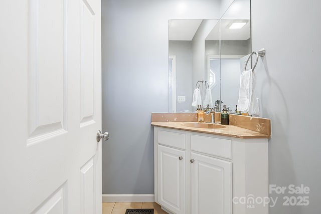 bathroom with baseboards, vanity, and tile patterned floors