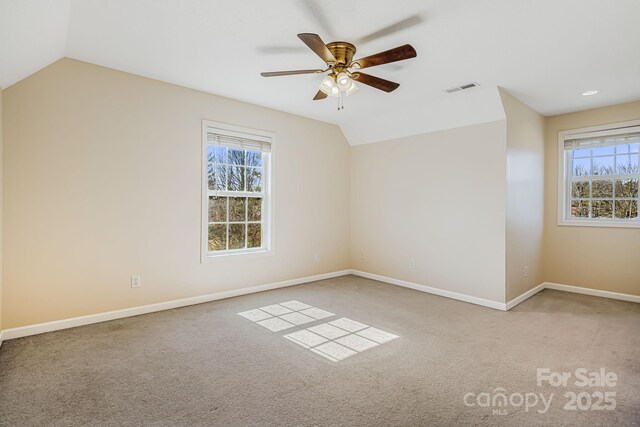 unfurnished room with lofted ceiling, baseboards, visible vents, and light colored carpet