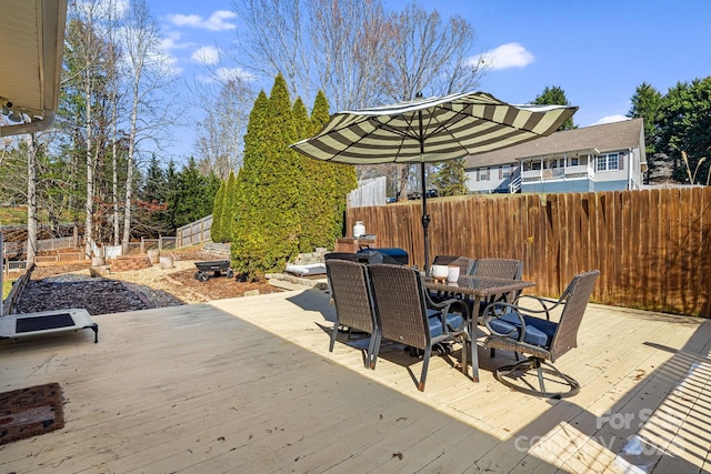 wooden deck featuring outdoor dining space and a fenced backyard