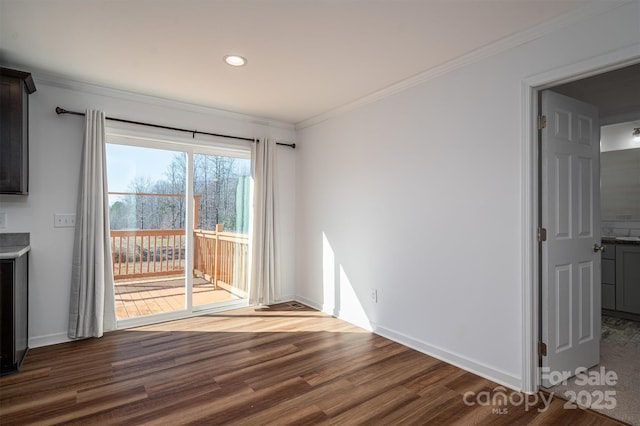 interior space featuring dark wood-type flooring, ornamental molding, and baseboards