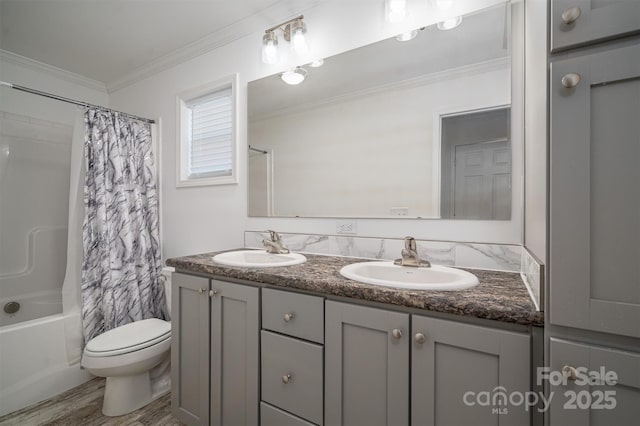 bathroom with crown molding, a sink, shower / bathtub combination with curtain, and toilet