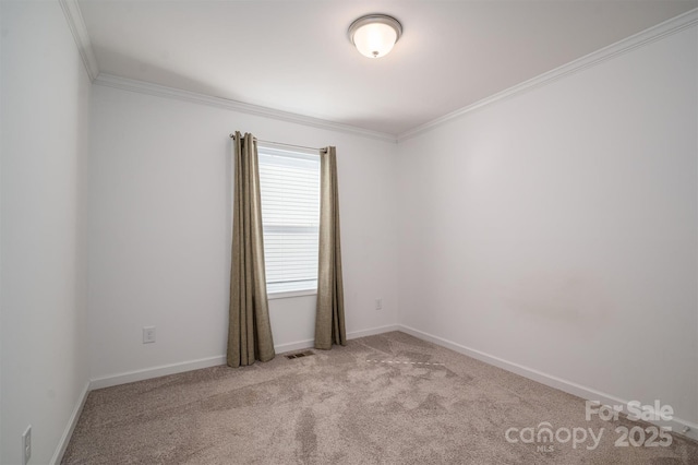 empty room featuring crown molding, baseboards, visible vents, and light colored carpet