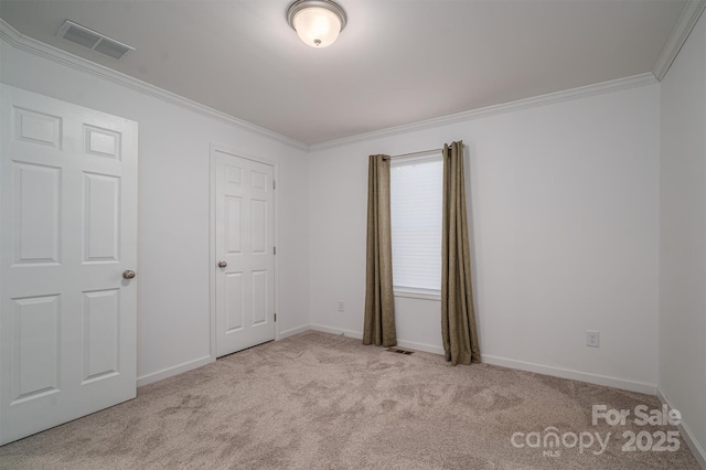 unfurnished bedroom featuring light colored carpet, visible vents, crown molding, and baseboards