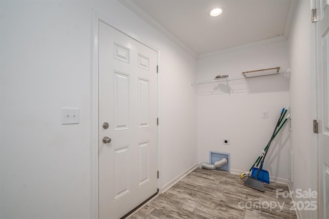 clothes washing area featuring laundry area, hookup for an electric dryer, crown molding, and wood finished floors