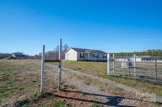 view of yard with a gate, fence, and a rural view