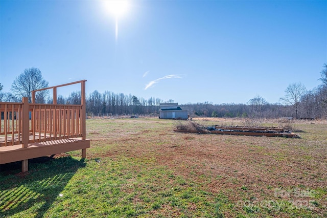 view of yard with a rural view and a wooden deck