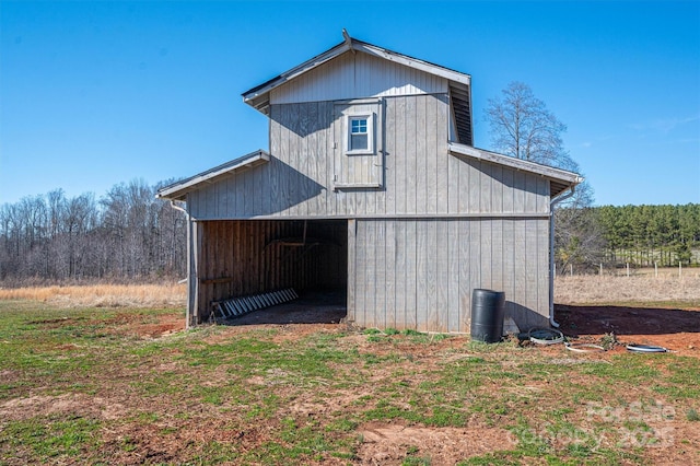 view of side of property with an outbuilding, a detached garage, and a barn