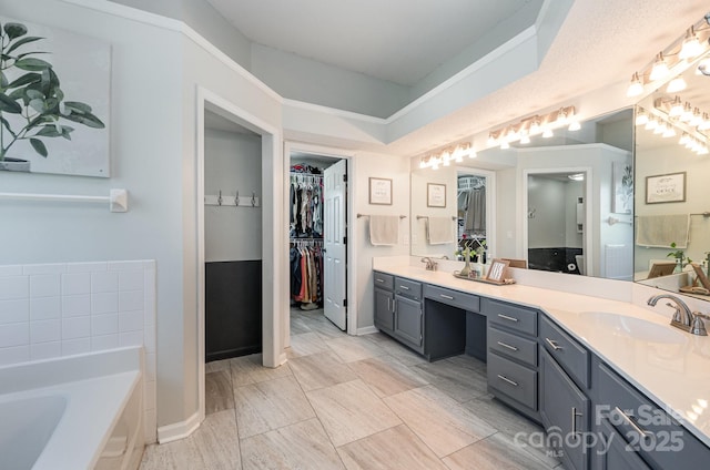 bathroom with double vanity, a sink, and a bath