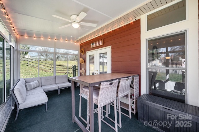 sunroom / solarium featuring ceiling fan and french doors