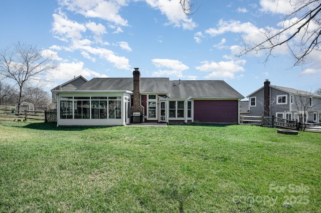 back of house featuring a lawn, fence, and a sunroom