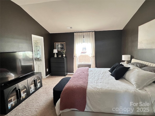 bedroom with lofted ceiling and light colored carpet