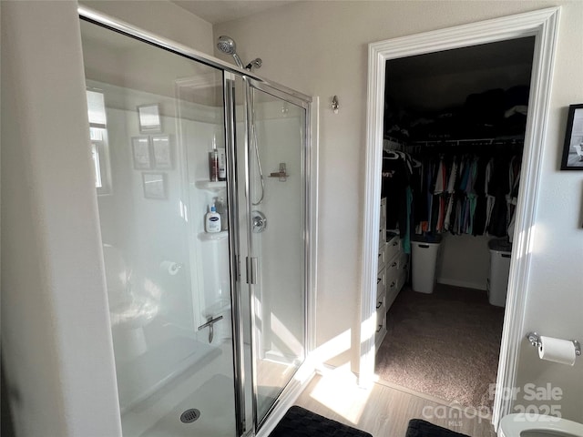 full bathroom with a spacious closet and a shower stall