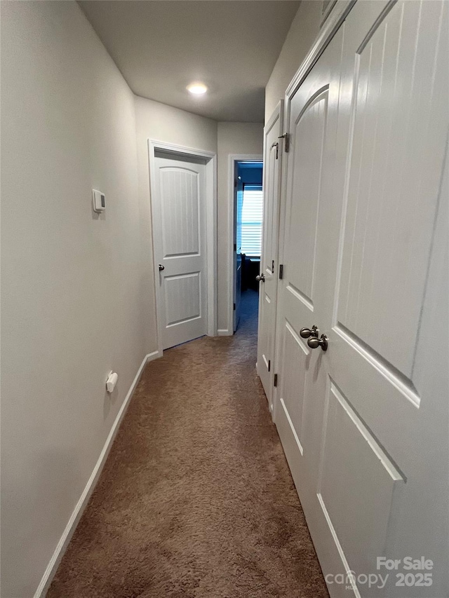 hall featuring carpet floors and baseboards