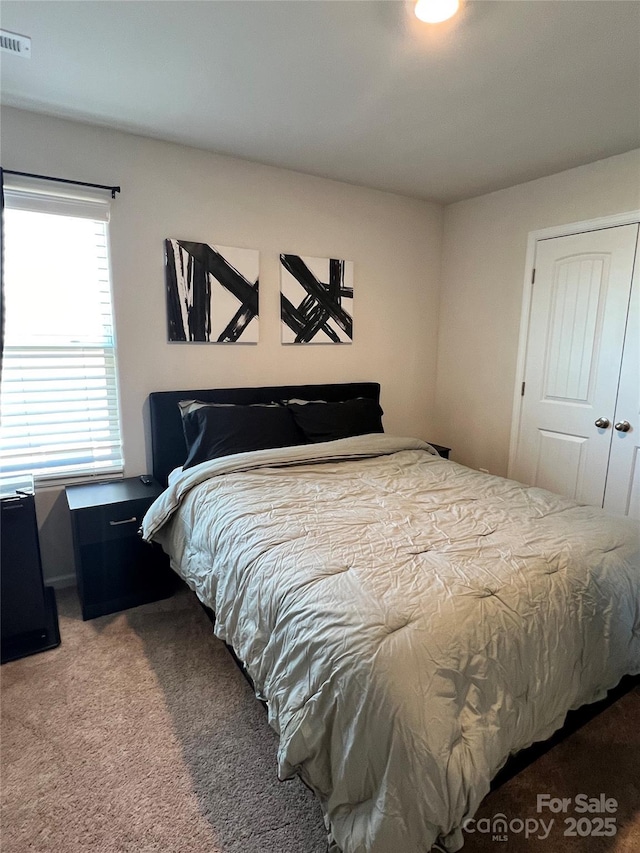 carpeted bedroom featuring visible vents