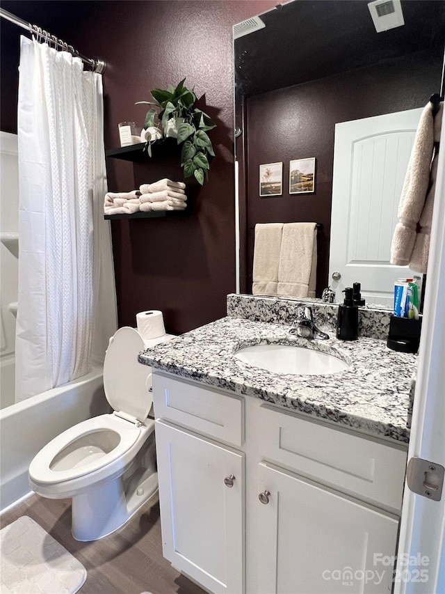 bathroom featuring shower / bath combo, visible vents, a textured wall, toilet, and vanity