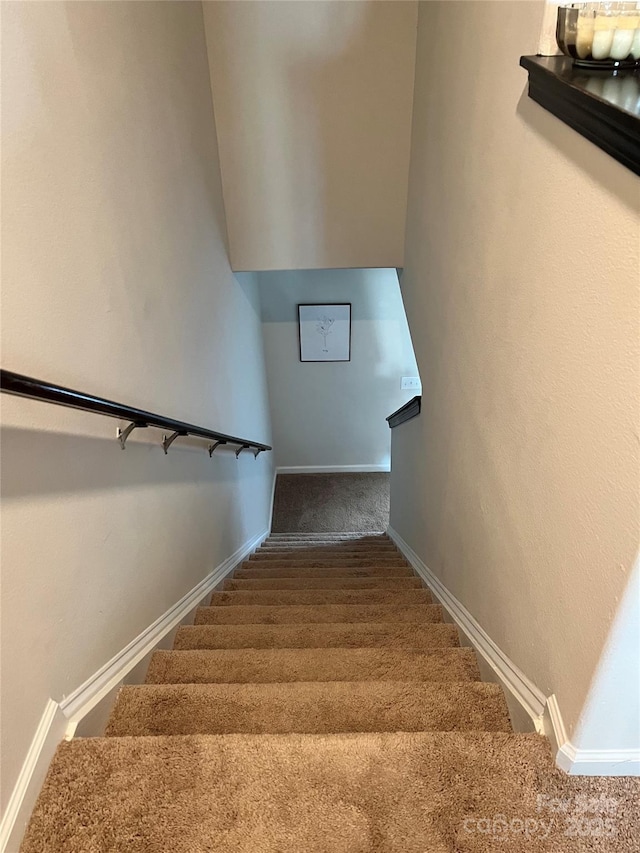 stairway featuring carpet floors and baseboards