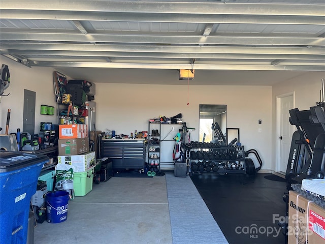 garage with electric panel, a workshop area, and a garage door opener