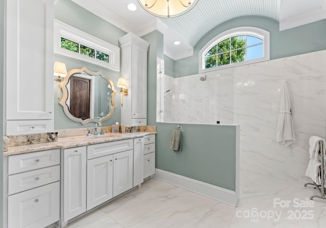 bathroom with marble finish floor, crown molding, lofted ceiling, vanity, and walk in shower