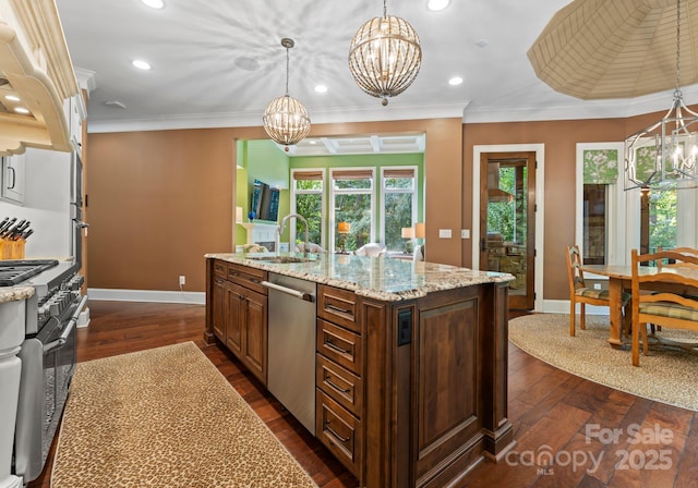 kitchen featuring an inviting chandelier, a kitchen island with sink, stainless steel appliances, and a sink