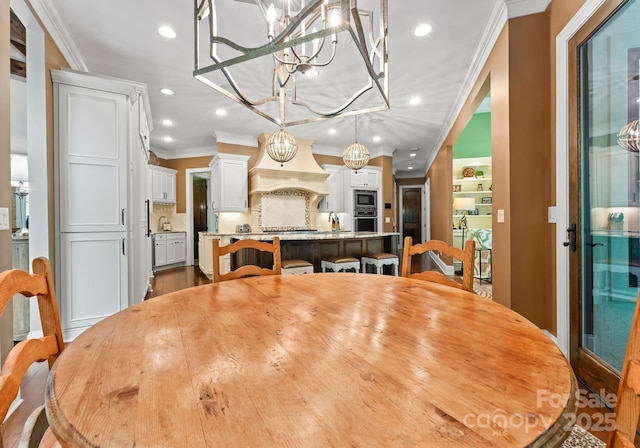 dining area featuring recessed lighting, crown molding, an inviting chandelier, and wood finished floors