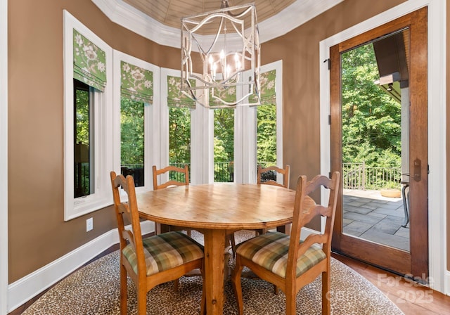 dining space with ornamental molding, a healthy amount of sunlight, a notable chandelier, and baseboards