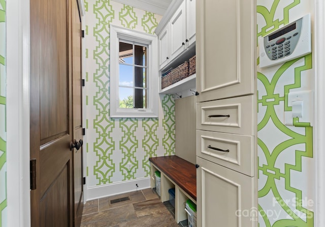 mudroom featuring baseboards, stone finish flooring, visible vents, and wallpapered walls