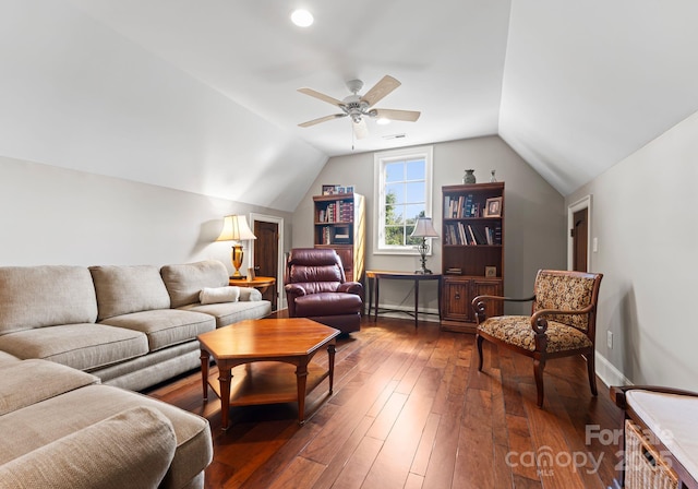 living room featuring dark wood-style floors, lofted ceiling, visible vents, a ceiling fan, and baseboards