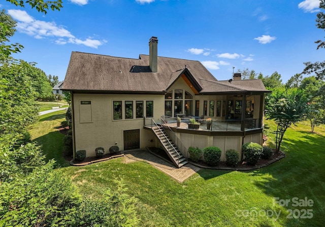 rear view of property featuring stucco siding, stairway, a deck, and a yard