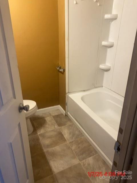 bathroom with toilet, baseboards, and shower / bathtub combination