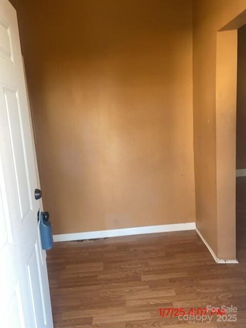 unfurnished room featuring wood finished floors and baseboards