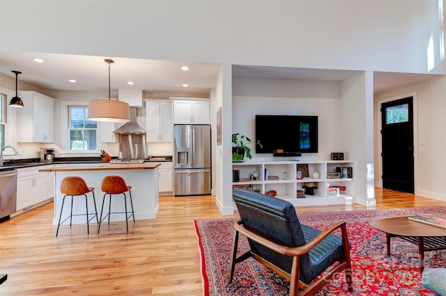 living area with light wood-style floors, baseboards, and recessed lighting