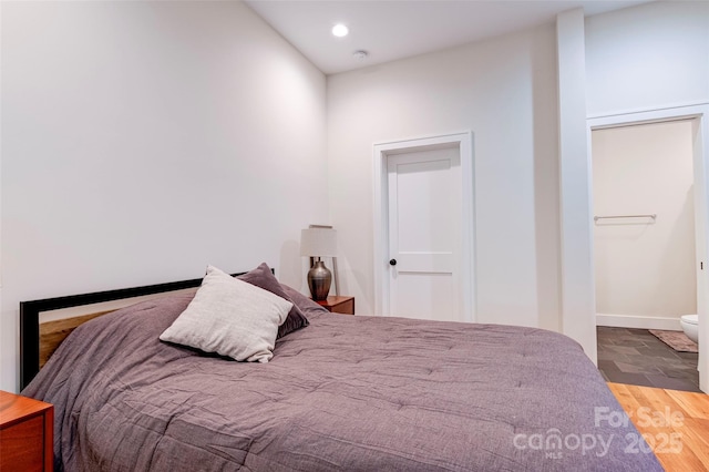 bedroom featuring baseboards, wood finished floors, and recessed lighting