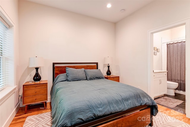 bedroom with light wood-type flooring, connected bathroom, and recessed lighting