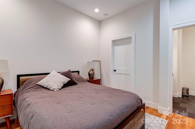 bedroom with recessed lighting, baseboards, and wood finished floors