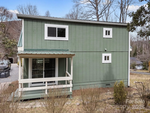 view of front facade with a porch, metal roof, and crawl space