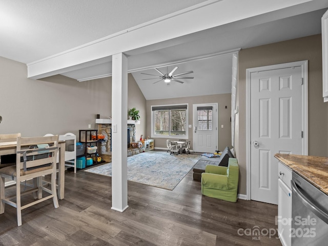 living area featuring a ceiling fan, baseboards, dark wood finished floors, vaulted ceiling with beams, and a fireplace