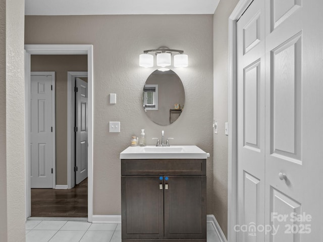 bathroom featuring tile patterned floors, a closet, vanity, and baseboards