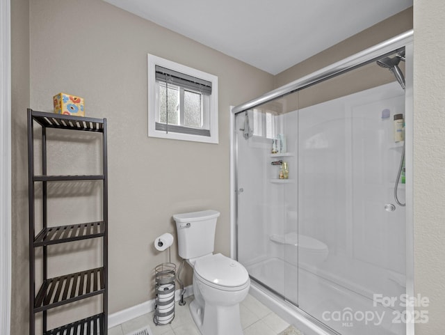 full bathroom with tile patterned floors, baseboards, toilet, and a stall shower