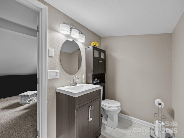 half bathroom with tile patterned flooring, toilet, vanity, and baseboards