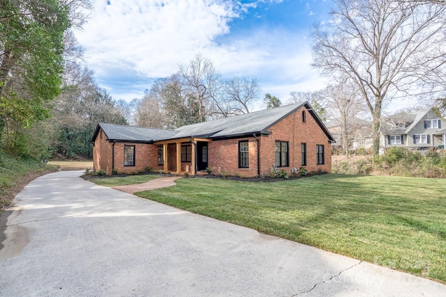 view of front of house featuring driveway, a front lawn, and brick siding