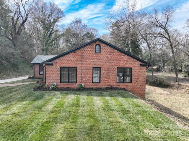 view of home's exterior with a yard and brick siding