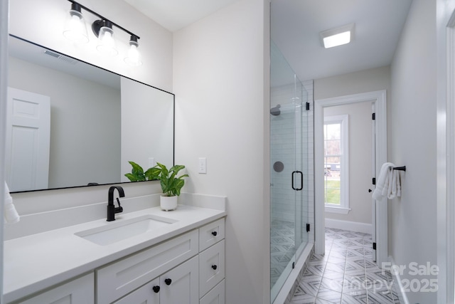 full bath with a stall shower, baseboards, and vanity