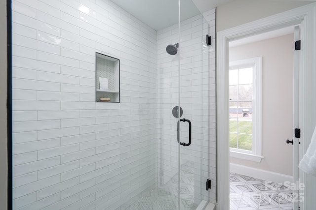 bathroom featuring a stall shower and baseboards