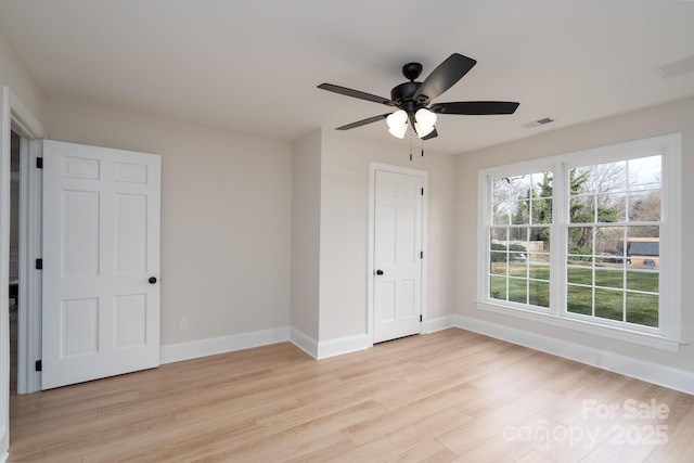 unfurnished bedroom featuring a ceiling fan, light wood-type flooring, visible vents, and baseboards