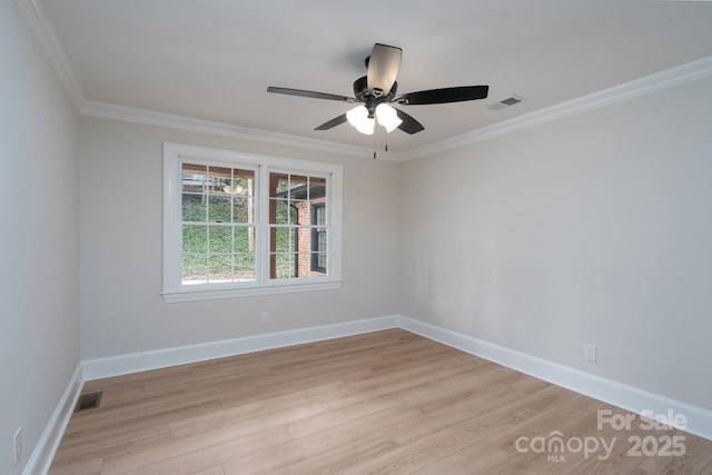 empty room featuring ornamental molding, light wood-type flooring, visible vents, and baseboards