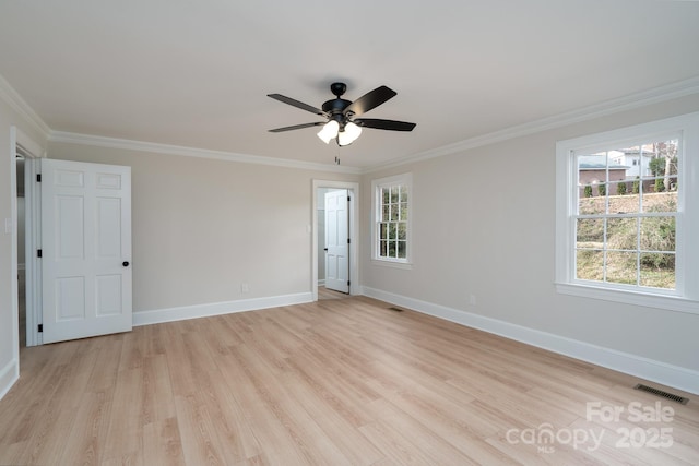 spare room featuring a ceiling fan, baseboards, visible vents, light wood-type flooring, and crown molding