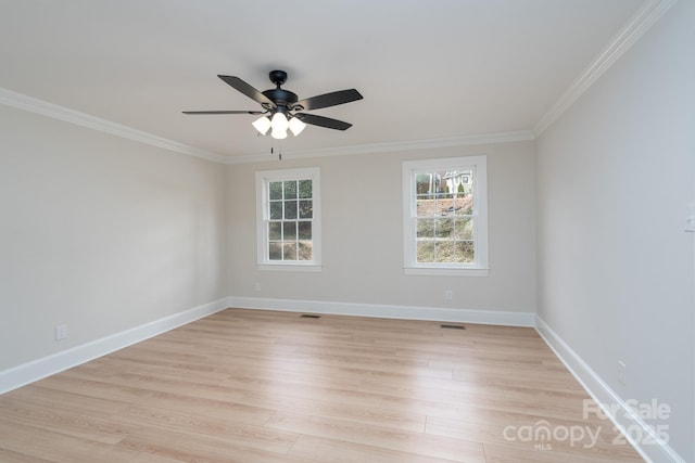 empty room with baseboards, visible vents, ceiling fan, ornamental molding, and light wood-style floors